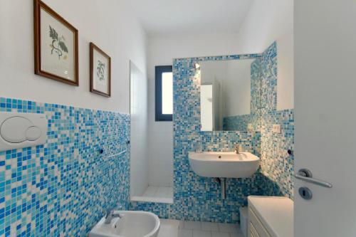 加拉托内坎皮拉提尼农家公寓式酒店的蓝色瓷砖浴室设有水槽和镜子