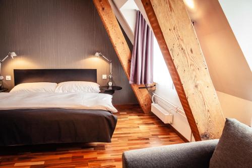 巴塞尔Royal Hotel - Urban Living的一间卧室配有一张大床和一把椅子