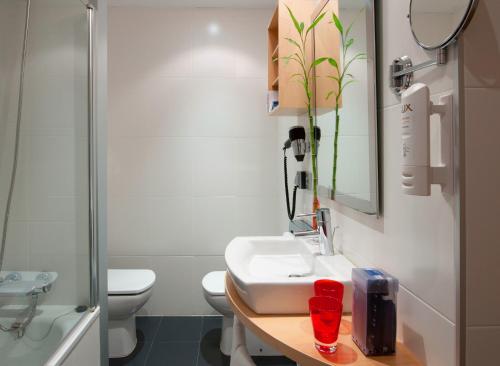 萨拉戈萨Hotel Zentral Ave的一间带水槽、卫生间和镜子的浴室