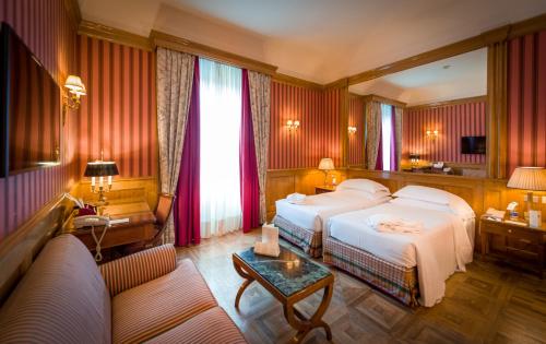 都灵西太大酒店的酒店客房,配有床和沙发