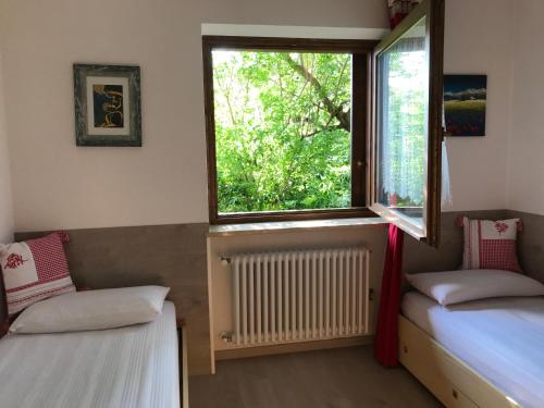 菲耶梅堡Almida的客房设有两张床、一个窗户和暖气。