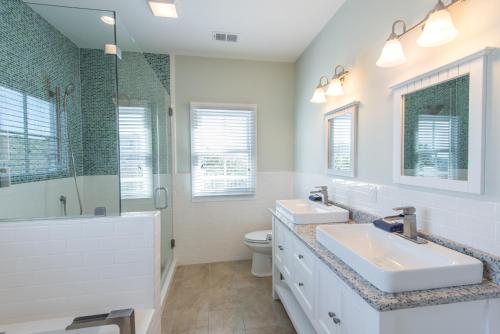富丽海滩121 E Ashley (A)的白色的浴室设有2个盥洗盆和淋浴。