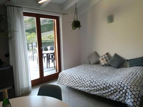阿科Appartamento Il Soffio的一间卧室配有一张床铺和一张桌子,并设有一个阳台