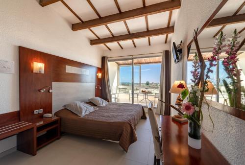 马瑟伊兰沙丘酒店的一间卧室配有一张床、一张书桌和一个窗户。