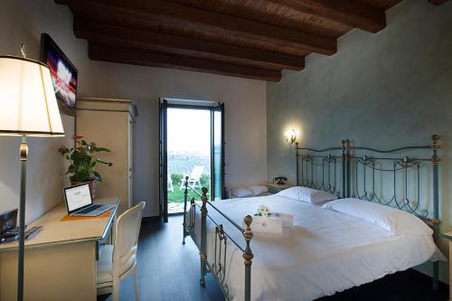 蒙泰普兰多内Agriturismo Il Sapore Della Luna的一间卧室配有一张床、一张书桌和一个窗户。