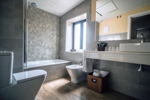科尔多瓦奥夫布雷庭院酒店的浴室配有卫生间、盥洗盆和浴缸。