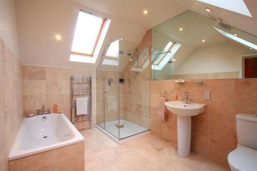 伦敦Wimbledon Tennis House with Hot Tub; 4 minute walk的带淋浴、盥洗盆和浴缸的浴室