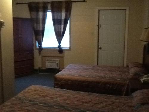 加蒂诺Motel Du Parc Masson的酒店客房设有两张床和窗户。