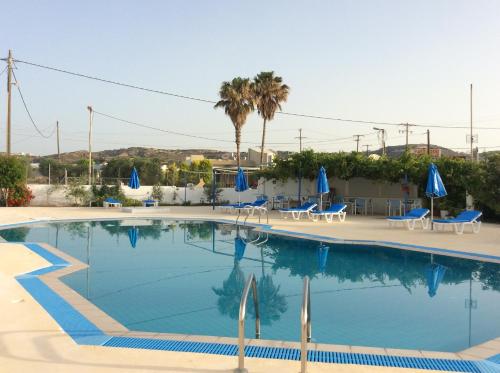 凯法洛斯安东尼酒店的一个带椅子和蓝伞的大型游泳池