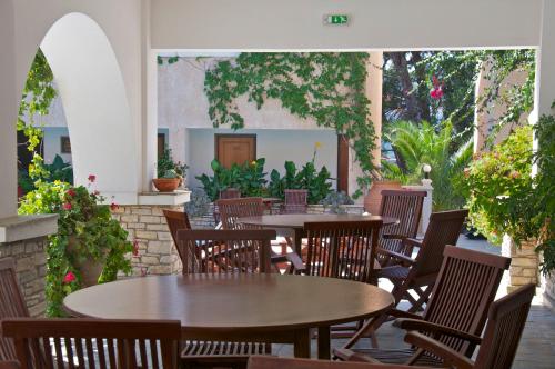萨摩斯伊诺村庄酒店的户外庭院设有桌椅和植物