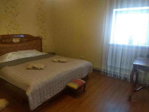 文尼察Hotel Andreevsky的一间卧室配有一张带桌子和窗户的床