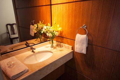 维纳德马Hotel Albamar的浴室设有水槽、镜子和鲜花