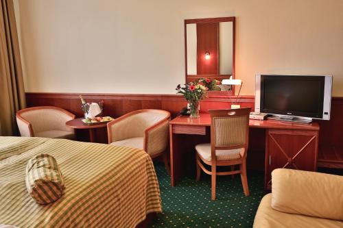 比尔森普利马维拉酒店及会议中心的酒店客房配有一张床和一张书桌及一台电视