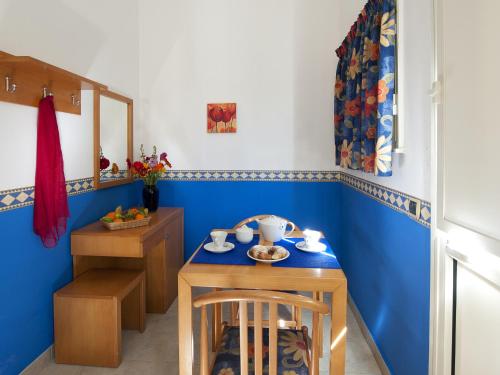 卡塔尼亚维拉吉奥阿尔伯格国际拉普拉加酒店的一间拥有蓝色墙壁和桌椅的用餐室