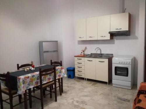 米内尔维诺迪莱切Appartamento Mare e Sole的厨房配有桌子、水槽和炉灶。