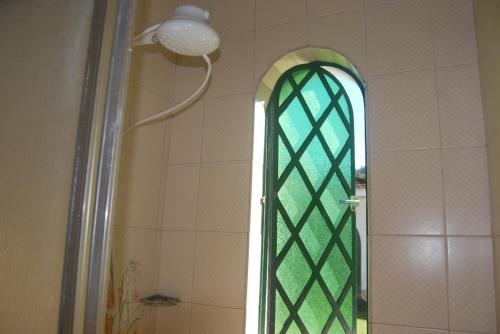 南蒙蒂阿莱格里Radicais Natureza的带淋浴的浴室和绿色玻璃窗