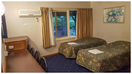 霍恩斯比阿斯科特汽车旅馆的酒店客房设有两张床和窗户。
