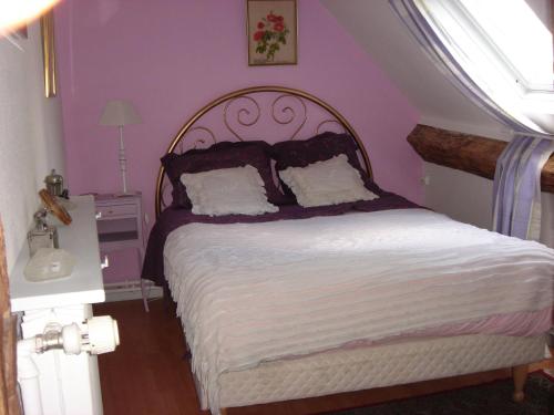 Mervegas的一间卧室设有一张紫色墙壁的大床