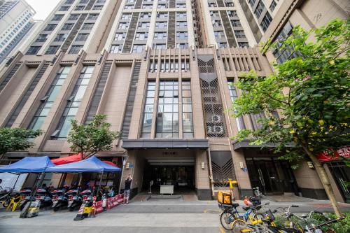 广州星寓传奇服务式公寓（广交会店）的一座高大的建筑,前面停有摩托车