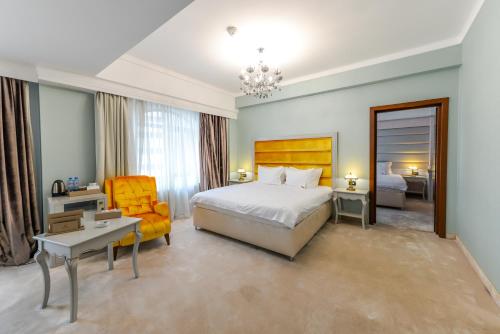 布加勒斯特腓尼基大酒店的配有一张床和一把椅子的酒店客房