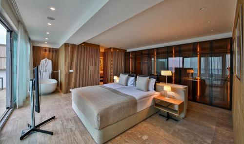 阿尔贝纳火烈鸟超豪华酒店及Spa的一间卧室设有一张大床和一个浴缸