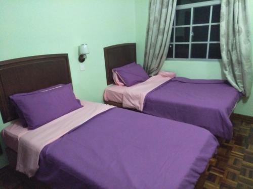 金马仑高原STAR REGENCY 407的紫色床单的客房内的两张床
