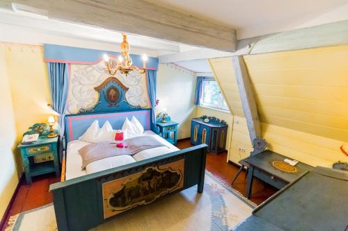沃尔特湖畔佩莎赫斯赫洛里恩斯丁酒店的一间卧室配有一张大床和一个吊灯。