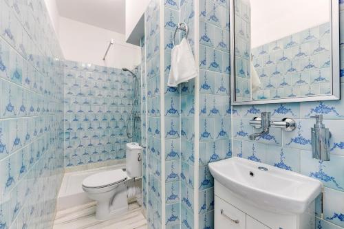 索波特Meduza Sopot的蓝色瓷砖浴室设有卫生间和水槽