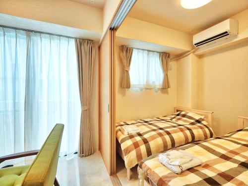 北谷町Mango Resort Okinawa Chatan的酒店客房设有两张床和窗户。