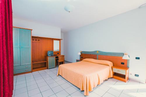 科里利亚诺·卡拉布罗Apulia Hotel Corigliano Calabro的一间卧室配有床和红色窗帘