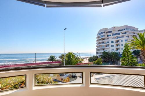 开普敦Backup Powered Sea View Apartment on the Promenade的享有海滩和大楼景致的阳台