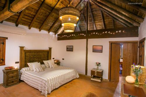 比利亚曼里克德拉孔德萨紫鹭酒店的一间卧室设有一张大床和木制天花板