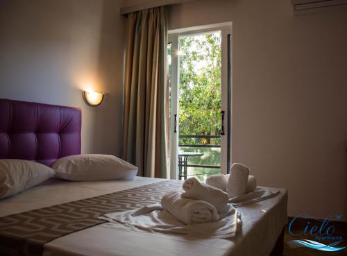 波罗斯Cielo Apartments的酒店客房,配有带毛巾的床