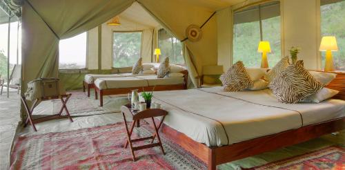 OlolaimutiekEntumoto Toto Camp的一间帐篷内带两张床的卧室