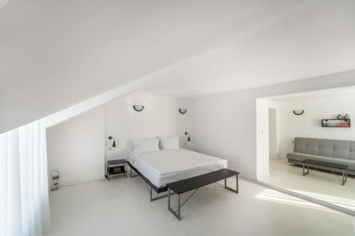 内塞伯尔Hotel Mistral的白色卧室配有床和沙发