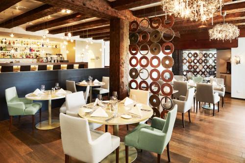 Uzwil乌兹维尔酒店的一间带桌椅和酒桶的餐厅