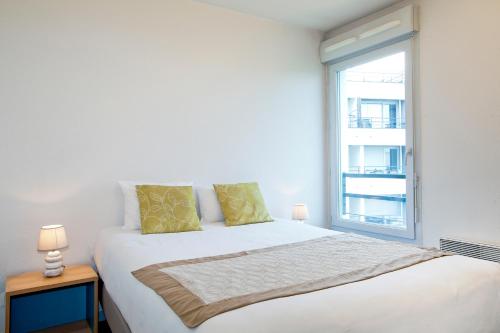 克莱蒙费朗塞祖尔阿菲尔克雷蒙费兰德共和公园酒店的白色卧室设有一张大床和窗户