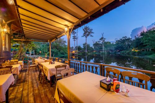华欣瓦纳瓦林度假酒店的河畔餐厅,配有桌椅