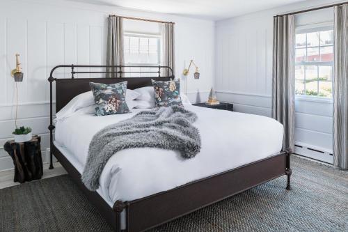法尔茅斯The Coonamessett的一间卧室配有一张带毯子和枕头的床。