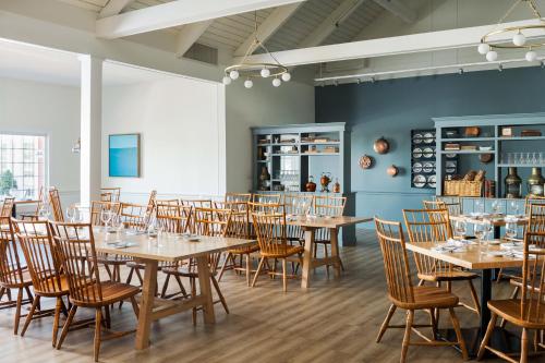 法尔茅斯The Coonamessett的用餐室配有木桌和椅子