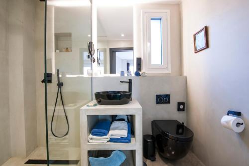 塔里法Kook Hotel Tarifa的一间带玻璃淋浴和水槽的浴室