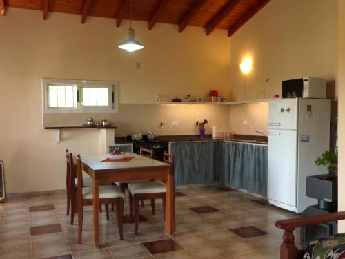 坦季El Pinar - Hospedaje Serrano的厨房配有桌子和白色冰箱。