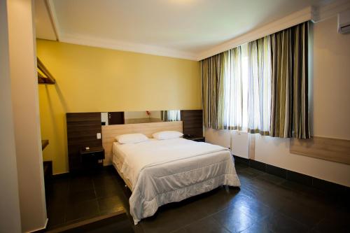博阿维斯塔艾帕纳广场酒店的卧室配有白色的床和窗户。