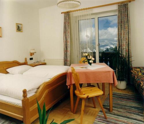 巴特圣莱昂哈德艾巴赫鲍尔酒店的一间卧室配有一张床、一张桌子和一个窗户。