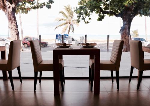 若昂佩索阿Hotel do Mar Cabo Branco的窗户客房内的桌椅