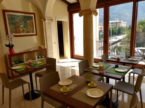 苏尔莫纳B&B Ponte Capograssi的一间带桌椅的用餐室和大窗户