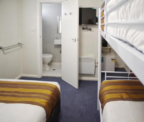 阿达米纳比Selwyn Star Lodge的一间小房间,设有两张双层床和一间浴室