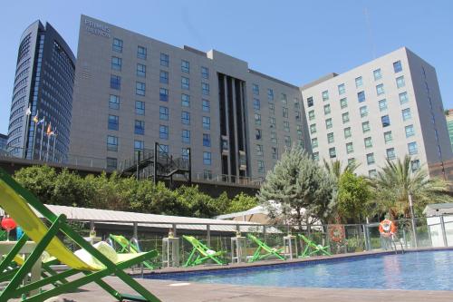 瓦伦西亚瓦伦西亚普里默斯酒店的酒店游泳池的背景建筑