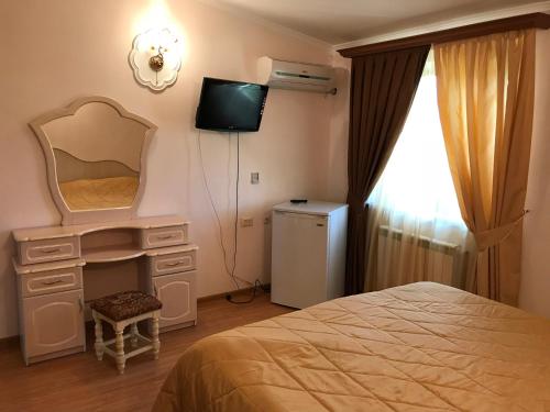 塞凡Armenia VanSevan Hotel的一间卧室配有一张床、镜子和电视