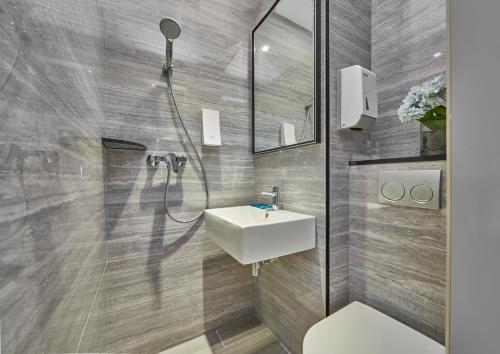 新加坡Hotel 81 Orchid的浴室配有白色水槽和淋浴。